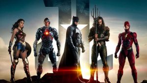From left; Wonder Woman, Cyborg, Batman, Aquaman and the Flash standing on atop mountain with two letters in back says JL which stands for Justice League.